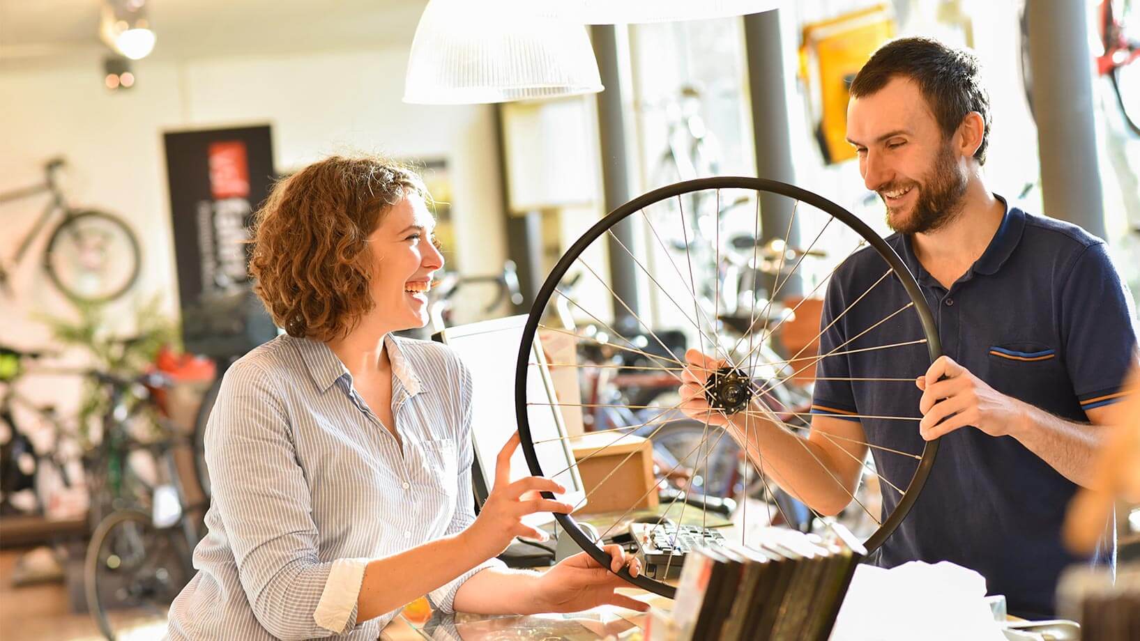 Das Bild zeigt eine Frau, die beim Kauf eines Fahrrad-Rades beraten wird. Hierbei wird das one-to-one-marketing verkörpert.