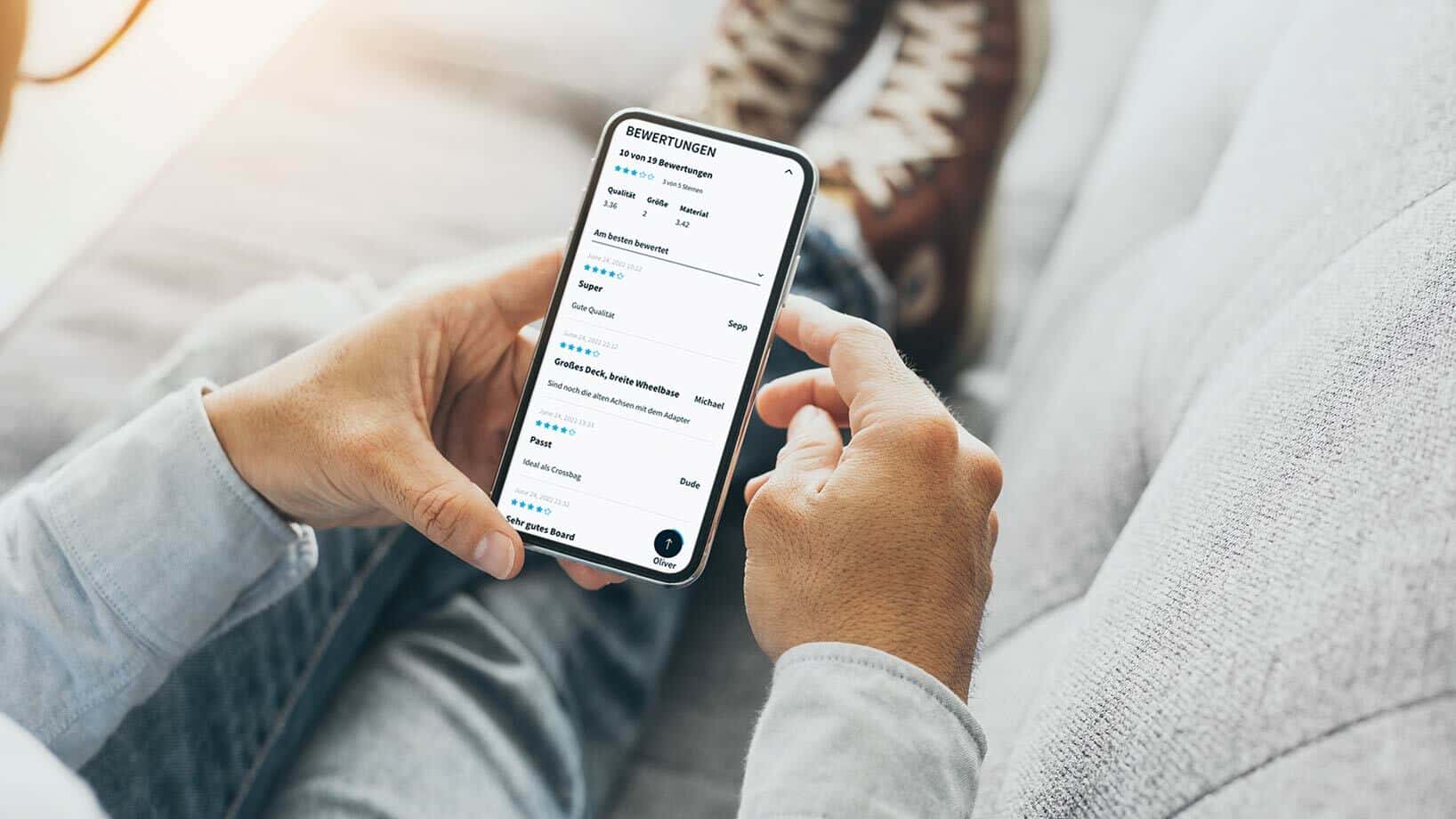 Eine Person hält ein Smartphone in der Hand, auf dem mehrere Produktbewertungen zu sehen sind.